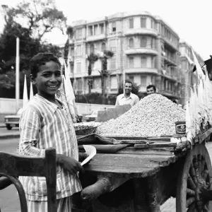 A child street vendor selling chick peas on the streets of Alexandria. 29th May 1976