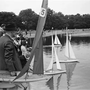 Children and adults sailing their toy yachts on the Round Pond in Kensington Gardens Children and adults sailing their toy yachts on the Round Pond in Kensington Gardens