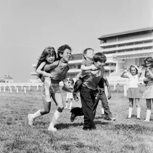 Children carrying their partners on their backs during a horse and jockey style egg