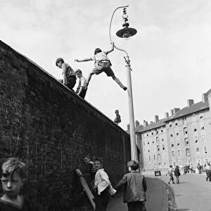 Children climb lamposts and scale high walls to get a better view of the England v