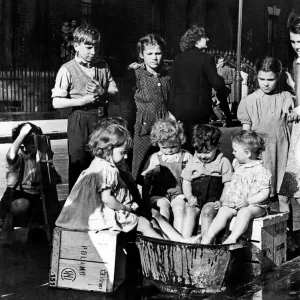 Children in East London take turns to keep cool with a large bucket of water 22nd June Children in East London take turns to keep cool with a large bucket of water 22nd June