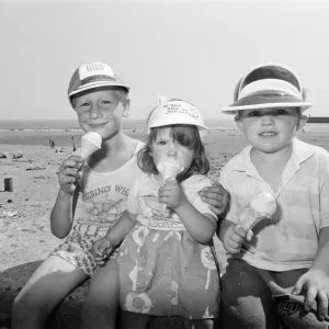 Children enjoy an ice cream as they try to keep cool on Coney Beach in Porthcawl Children enjoy an ice cream as they try to keep cool on Coney Beach in Porthcawl