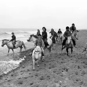 Children enjoying a seaside canter on the ponies despite the weather at Hornsea