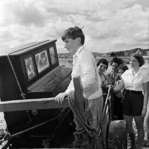 Children on Exmouth beach looking at an ancient Barrel Organ which Mr Percy Tucker