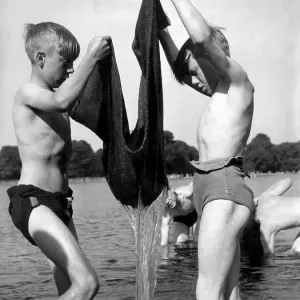Children fishing with the aid of a sack 5th June 1952. The youngsters drag