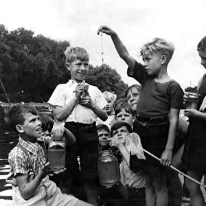 Children fishing on th bank of a river August 1952