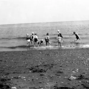 Children having fun in the sea at an unknown beach in England. Circa 1929 Children having fun in the sea at an unknown beach in England. Circa 1929