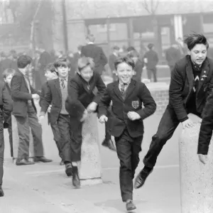 Children of a London Comprehensive school leap frogging over one of the concrete pillars