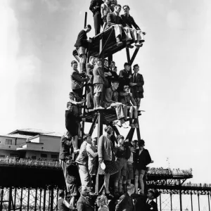 Children make a human pyramid on a lifeguard look-out tower at a Butlins holiday camp