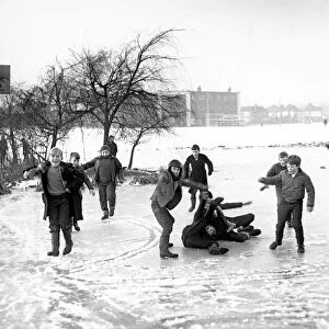 Children play on the ice formed on Quinton Pool, Cheylesmore, Coventry