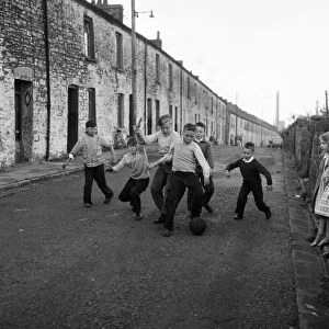 Children playing football in the road. Ebbw Vale, Blaenau Gwent, Wales. September 1960