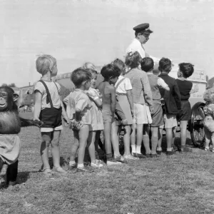 Children queue with their Chimpanzee friend for an ice cream at Billy Smart Circus Children queue with their Chimpanzee friend for an ice cream at Billy Smart Circus