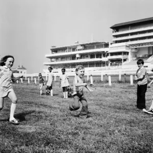 Children race across the finish line of the egg and spoon race on the Downs at Epsom