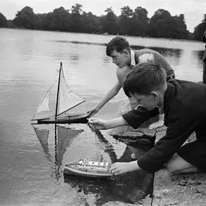 Children sailing their toy yachts on the Round Pond in Kensington Gardens, London Children sailing their toy yachts on the Round Pond in Kensington Gardens, London