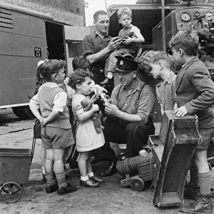 Children from Stoke Newington bring their broken toys to Leading Fireman Herbert Rogers