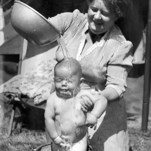 Children: Washing: Mrs. Ann Farrier gives her son 8 months old John his morning bath in a Children: Washing: Mrs. Ann Farrier gives her son 8 months old John his morning bath in a