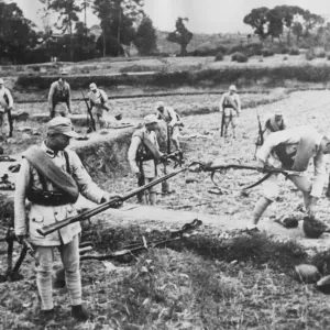Chinese soldiers pick up the discarded weapons of Japanese soldiers who have fled Chinese soldiers pick up the discarded weapons of Japanese soldiers who have fled