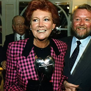 Cilla Black, dressed in a black and pink chequered jacket