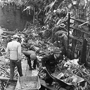 Civilians and firemen help to clear wreckage after another World War Two air raid over