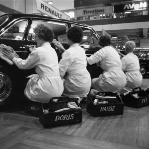 Quatre femmes de ménage nettoyant l'un des moteurs à la Foire du Motor show d'Earls Court.