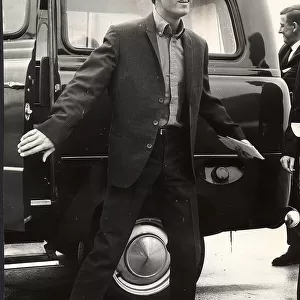 Cliff Richard in glasses getting out of a taxi 1964