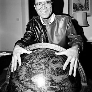 Cliff Richard with a globe. 5th January 1984