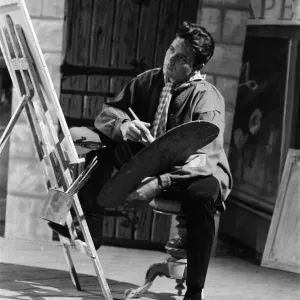 Cliff Richard on the set of the film Summer Holiday, painting with a brush and easel Cliff Richard on the set of the film Summer Holiday, painting with a brush and easel