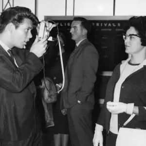 Cliff Richard taking a picture of his Mother at London Airport before leaving for New Cliff Richard taking a picture of his Mother at London Airport before leaving for New