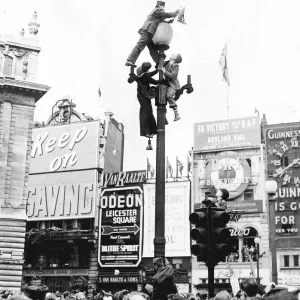 Climbing a lamppost in Piccadilly Circus London to get a better view of the VE-Day Climbing a lamppost in Piccadilly Circus London to get a better view of the VE-Day