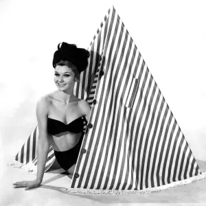 Clothing Beach 1963. Model Merril Weston shows how to use the striped cape-tent Clothing Beach 1963. Model Merril Weston shows how to use the striped cape-tent