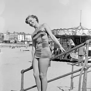 Clothing Beach wear swimsuits fashion April 1952 Model standing on steps wearing a