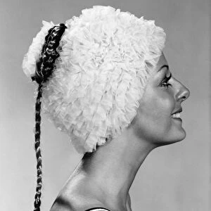 Clothing : Beach. Woman models a frilly swimming hat. October 1970 P017299