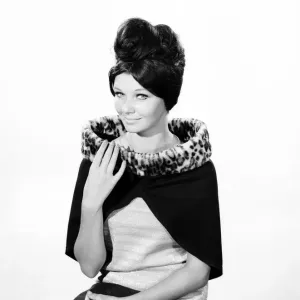 Clothing: Fashion: Hats: Woman wearing fur edged shrug wrap. 1962 B1544-030