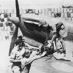 Co-operating Naval and RAF ground crews re-arm a Spitfire plane on an aerodrome in Malta