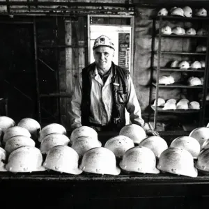 Coal - Miners - Coal miner checks the miners hats at a South Wales Colliery Coal - Miners - Coal miner checks the miners hats at a South Wales Colliery