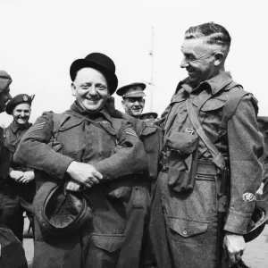 Colour Sergeant J. E. Pardoe (left) tries on a bowler hat in Gibraltar whilst waiting to Colour Sergeant J. E. Pardoe (left) tries on a bowler hat in Gibraltar whilst waiting to