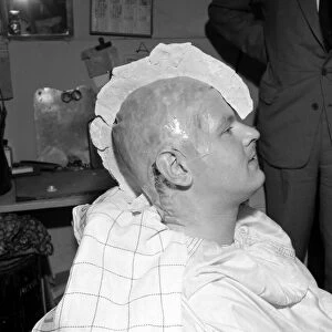 Comedian Benny Hill having a plaster cast of his skull made