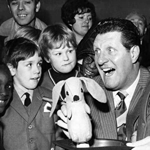 Comedian and magician Tommy Cooper pulls a rabbit out of the hat during a demonstration