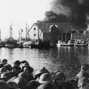 Commandos sail for home as a Stamsund objective burns. Circa 1940s Commandos sail for home as a Stamsund objective burns. Circa 1940s