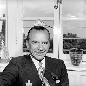 Conductor: Sir Malcolm Sargent with his pet budgie. July 1957