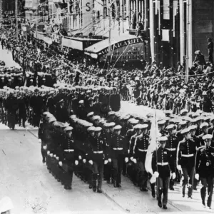 Confetti showers upon US Sailors and Marines who march with men of the Australian Navy