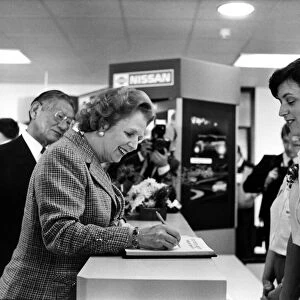 Conservative Prime Minister Margaret Thatcher, signs the visitors book at the Nissan