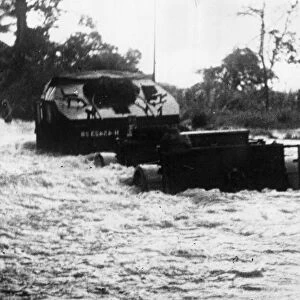 A convoy of British 25 pounders navigate a flooded section of road on their way up