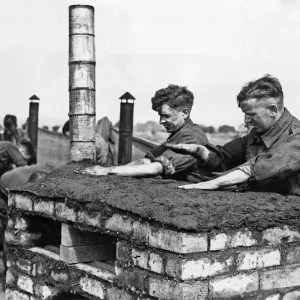 Cooks at an army school of cookery in the Midlands patting a crust of earth in completing