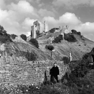 Corfe Castle Dorset rises behind a drystone wall. Corfe Castle Corfe Castle Dorset rises behind a drystone wall. Corfe Castle