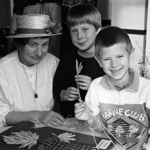 Corn-dolly maker Mrs Marie Jolliff shows Alex Krzesinski (centre Corn-dolly maker Mrs Marie Jolliff shows Alex Krzesinski (centre