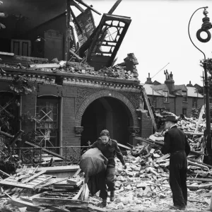 Print of a man salvaging bedding from his wrecked London home
