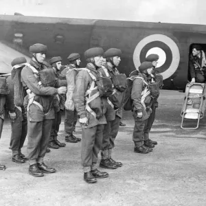 The corporal inspecting the parachute equipment of British parachutists before they enter The corporal inspecting the parachute equipment of British parachutists before they enter
