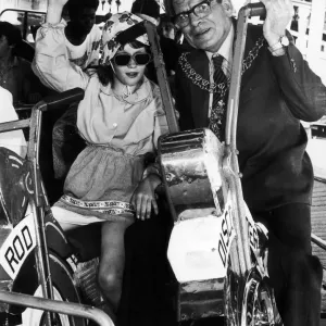 Councillor Weaver with one of the youngsters from Wisteria Lodge on the merry-go-round