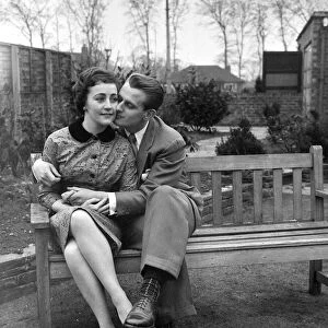 Couple Catherine Egan and Francis Byrne cuddling on a wooden bench in Liverpool